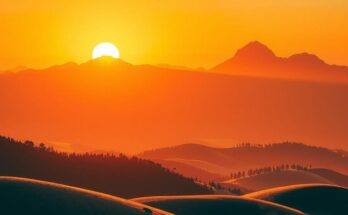 Golden sunrise over mountains with an orange hue, reflecting dedication and commitment.